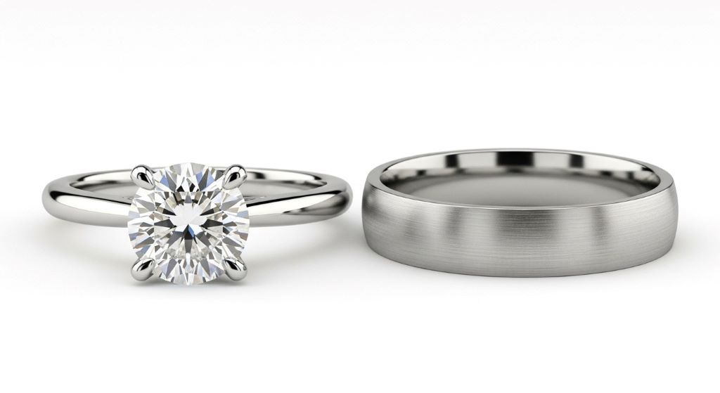 Side by side comparison of solitaire diamond engagement ring next to simple platinum wedding band on white background